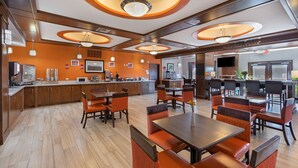 Un hall d’hôtel moderne doté d’un espace de restauration central, d’une cuisine et d’un bar.