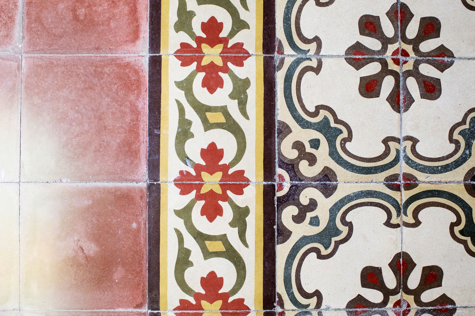 A close-up of a tiled wall with various patterns and colors.