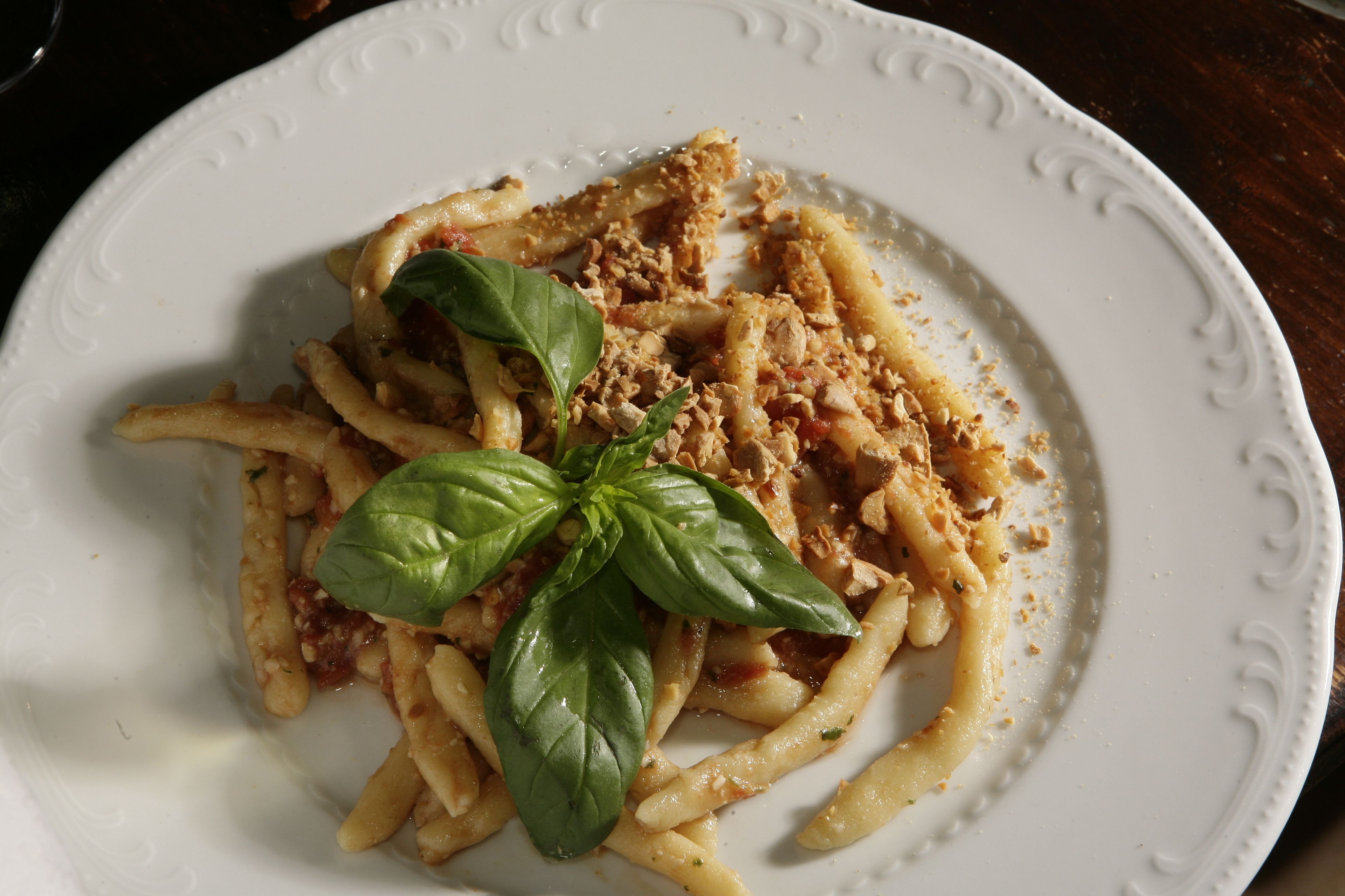 A plate of pasta with a basil leaf garnish.