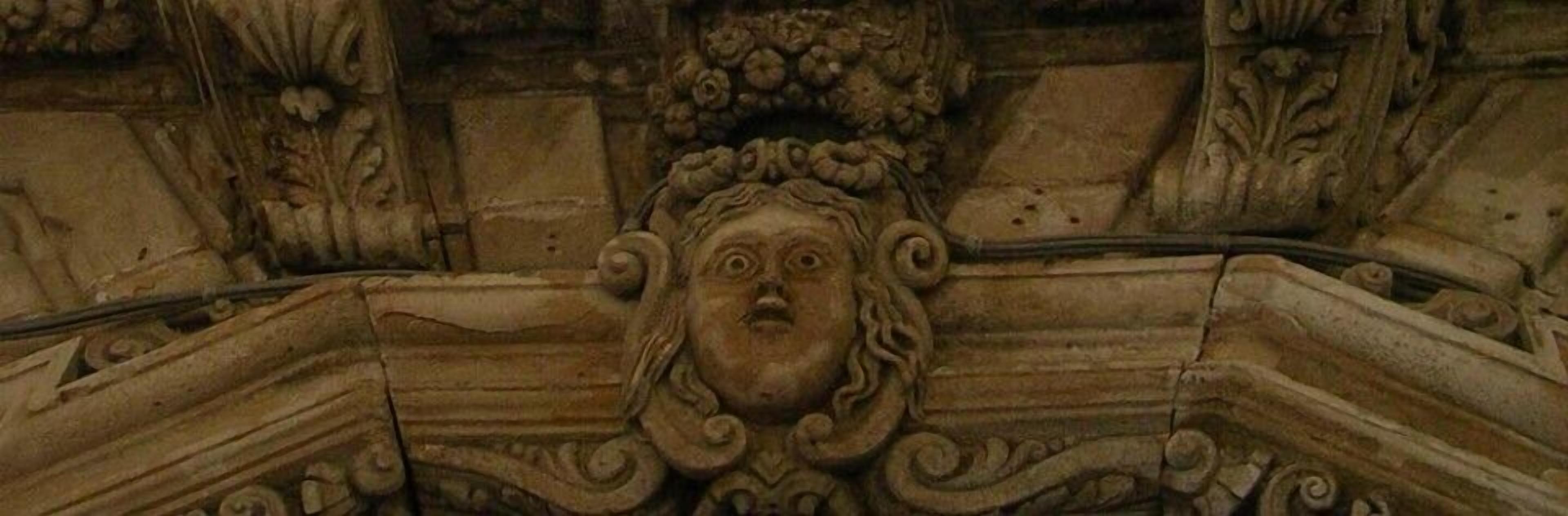 Una dettagliata scultura in pietra con motivi intricati e una figura centrale.