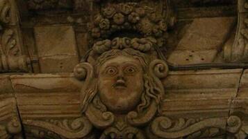 Una dettagliata scultura in pietra con motivi intricati e una figura centrale.