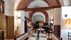 Un restaurant au décor rustique, avec des arches en briques apparentes, des meubles en bois et différents types de sièges, notamment des tables et des bancs.