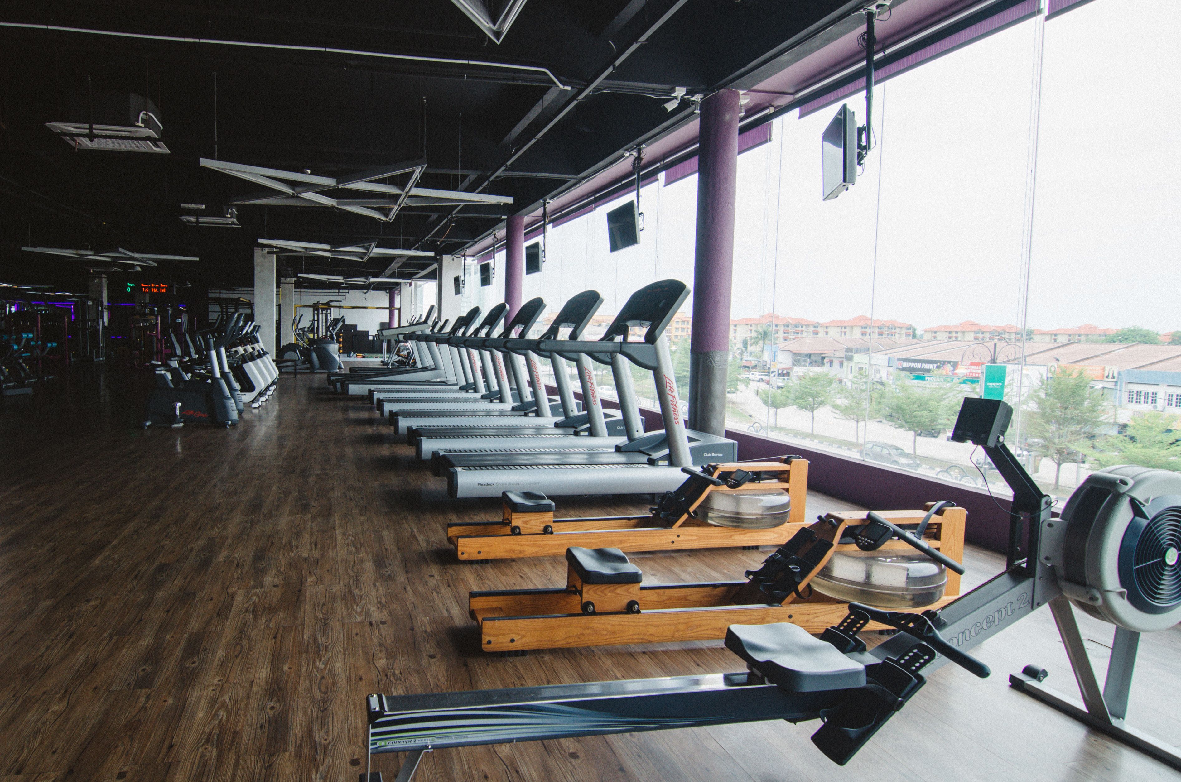 Un gimnasio con cintas de correr, máquinas de remo y equipo de ejercicio.