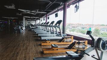 Un gimnasio con cintas de correr, máquinas de remo y equipo de ejercicio.