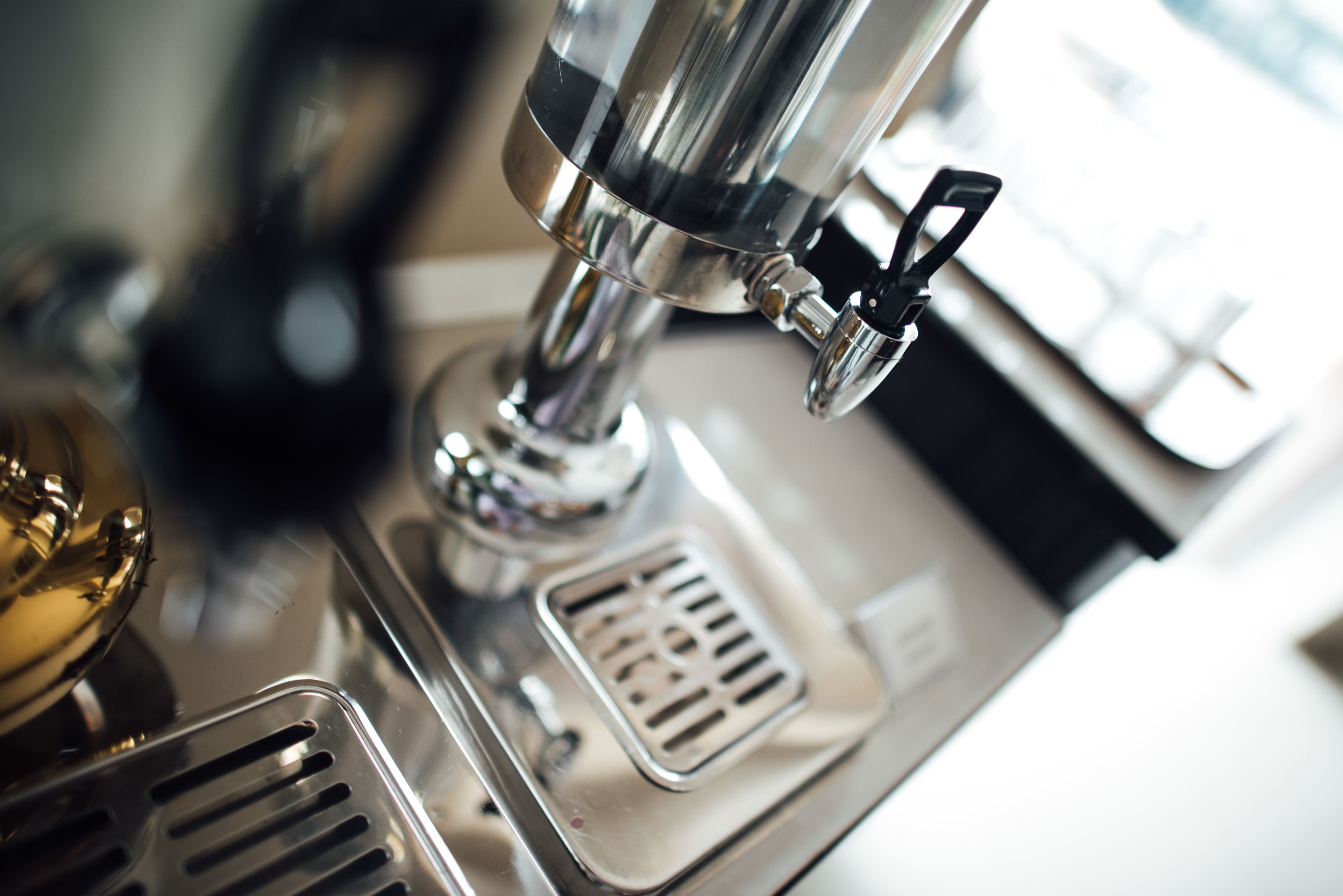 A close-up of a coffee machine with a metallic finish and a control knob.