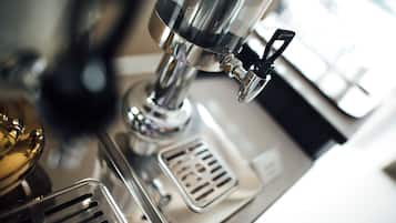 Primer plano de una cafetera con acabado metálico y un mando.
