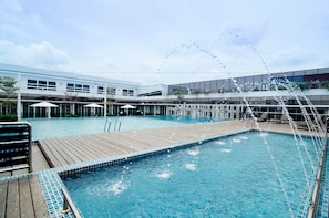 A swimming pool with a wooden deck and lounge chairs.