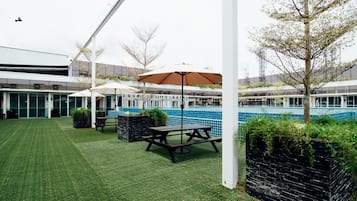Relax by the pool or enjoy a meal under the shade of two umbrellas in this serene outdoor space.
