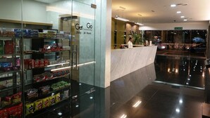Una tienda de conveniencia moderna con una vitrina de aperitivos y un letrero que indica servicio las 24 horas.