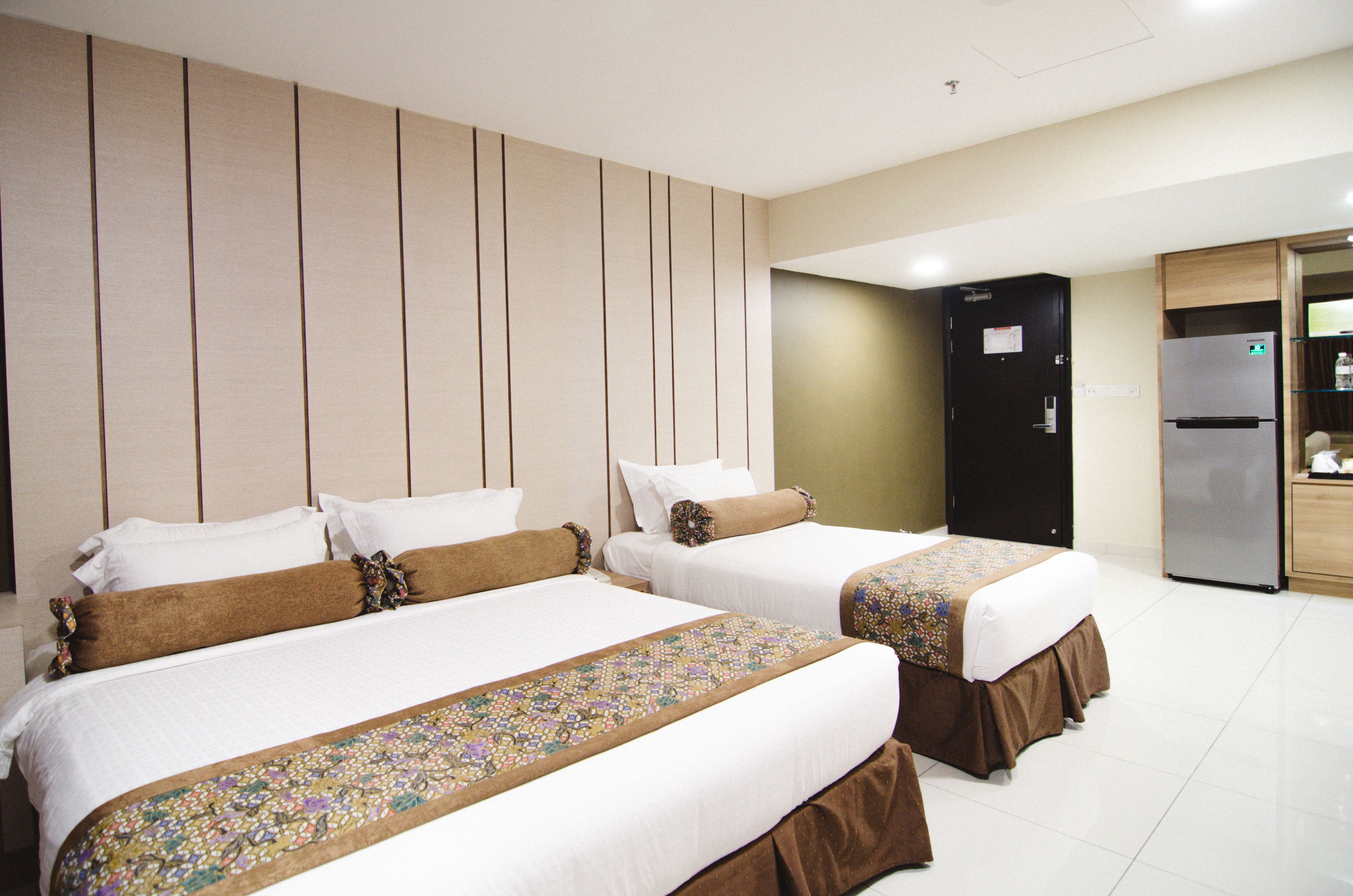 A hotel room with two beds, a refrigerator, and a minibar.