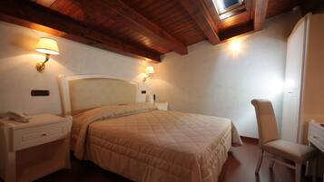 Un dormitorio con una cama grande, lámparas de noche, un escritorio y una silla.