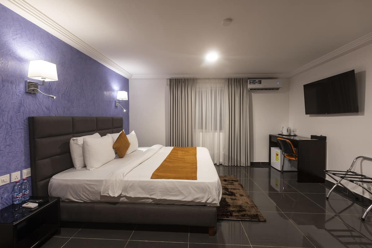 Executive kamer | Luxe beddengoed, een minibar, een kluis op de kamer, een bureau