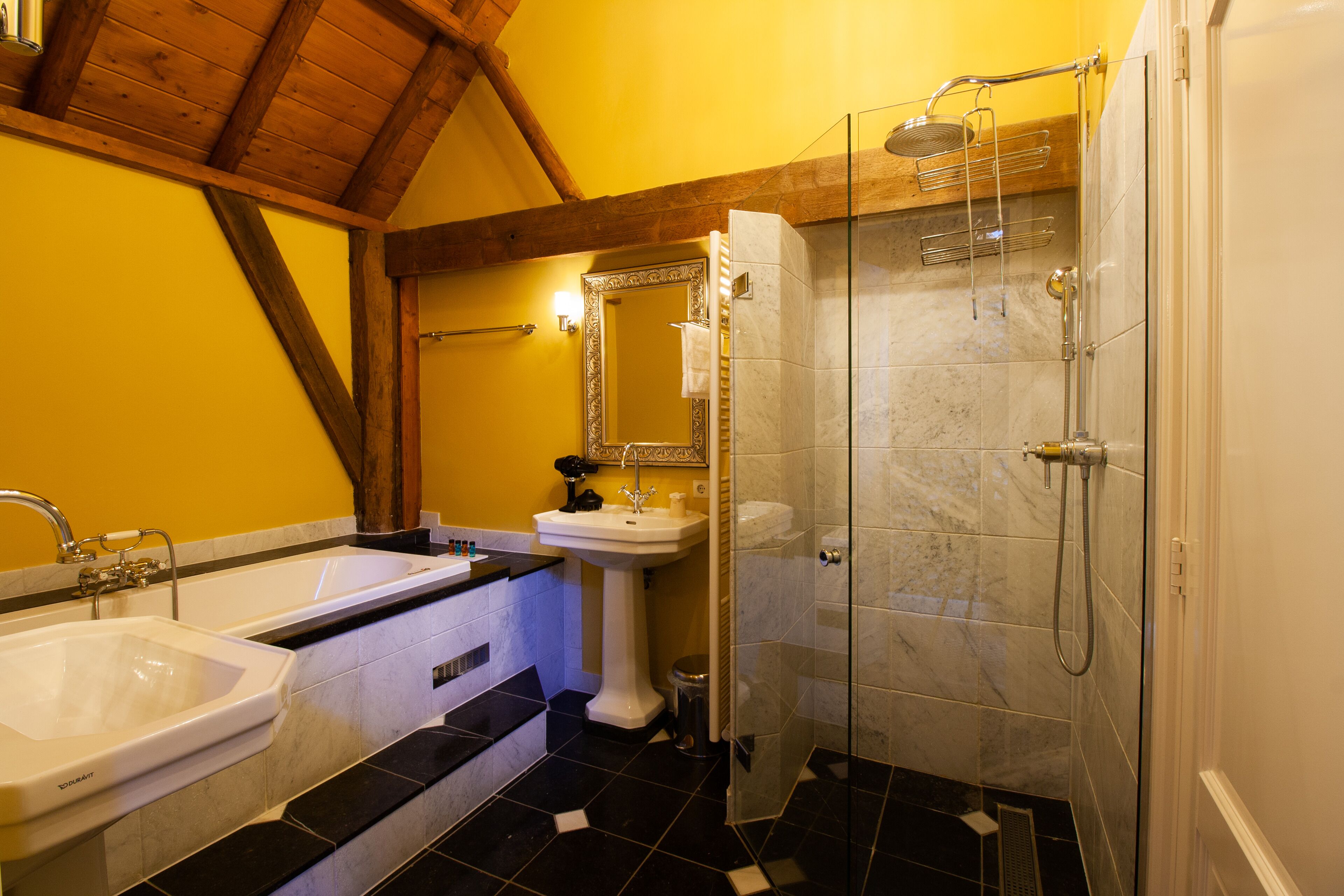 A bathroom with a bathtub, a sink, and a shower area.