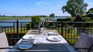 Mesa lista para comer con vistas a un río y un edificio lejano.