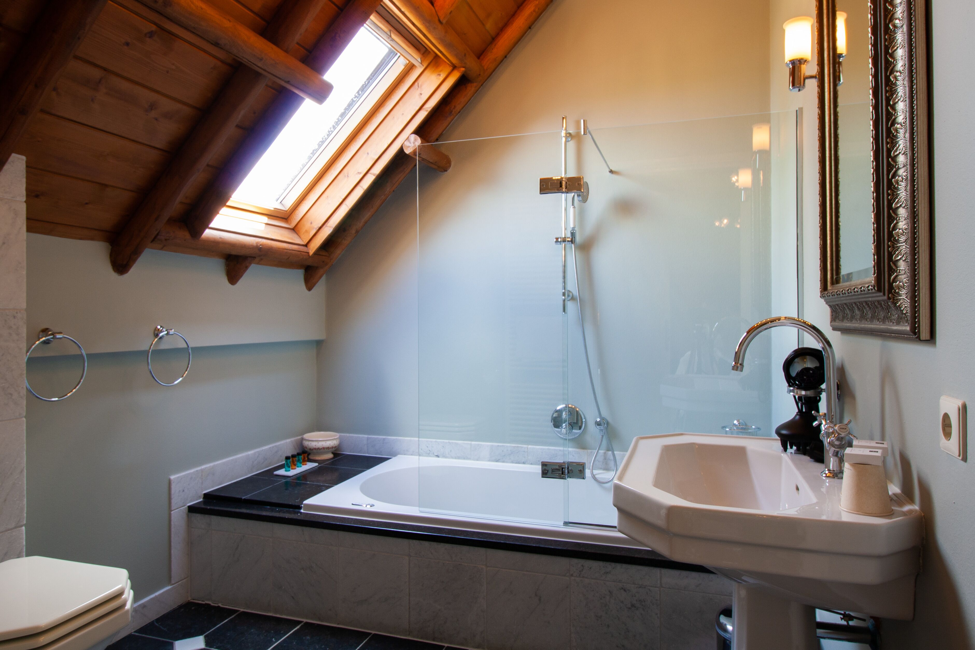 A modern bathroom with a glass-enclosed shower, a bathtub, and a sink.