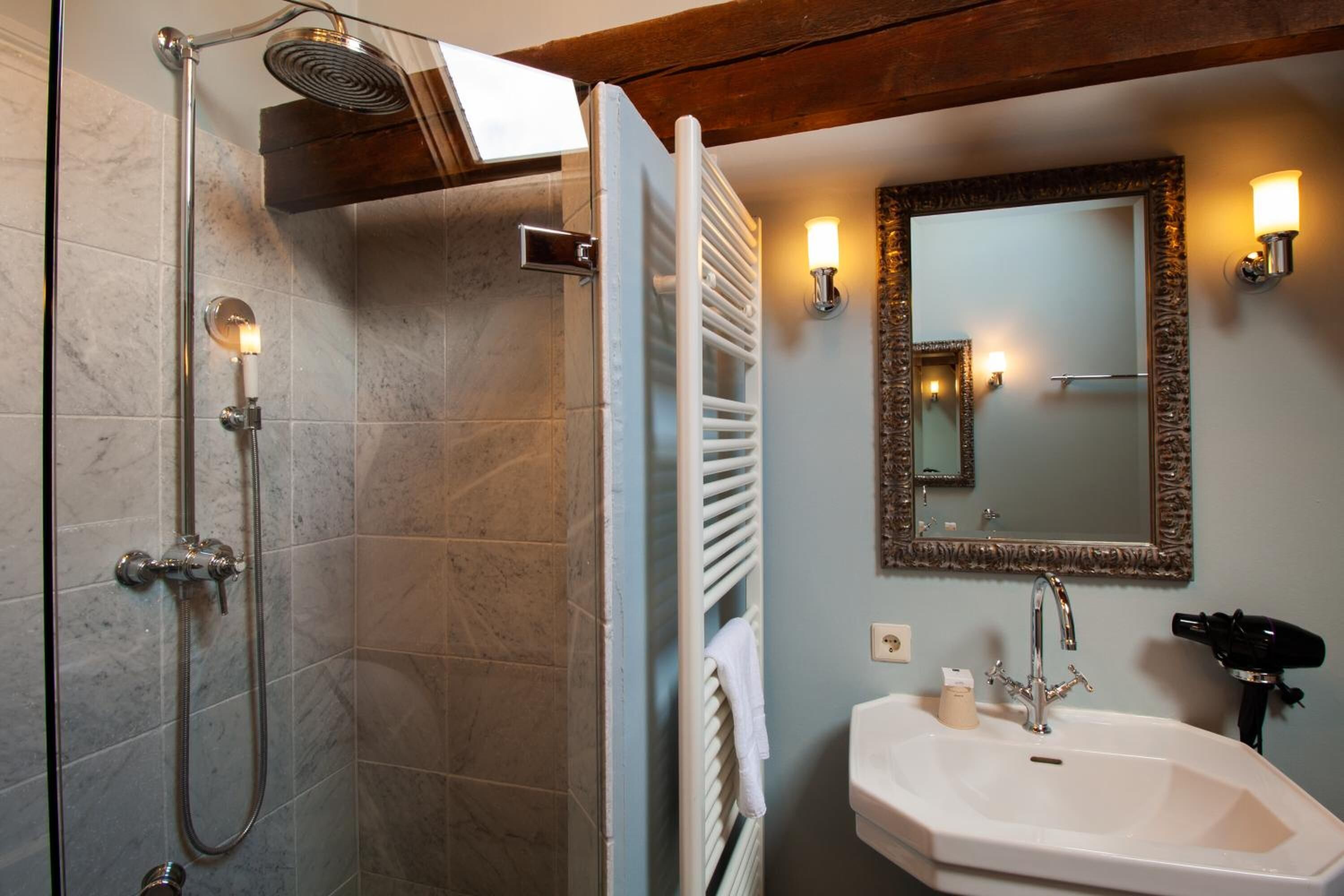 A bathroom with a shower, a sink, and a mirror.