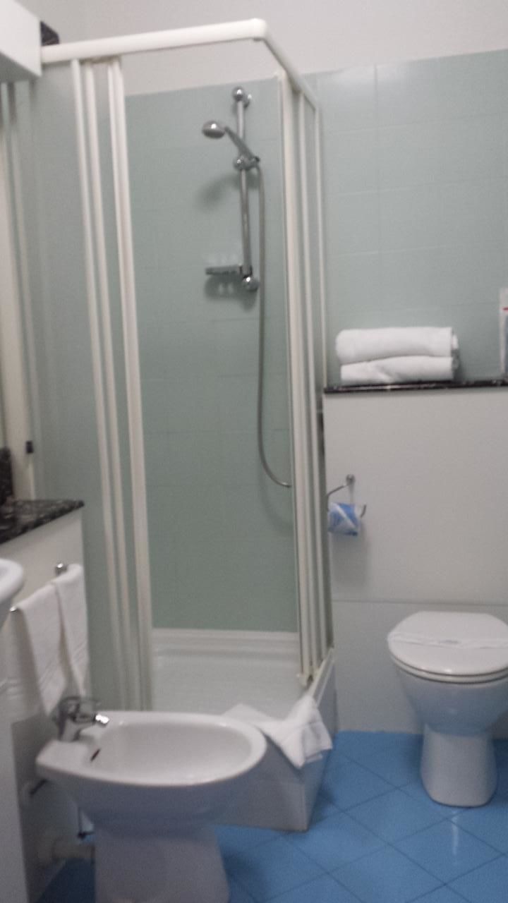 Ein Badezimmer mit Duschkabine, Waschbecken und Toilette.