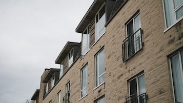 A multi-story building with a brick facade, large windows, and balconies.