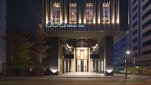 A modern building with a prominent 'DUA Boutique Hotel' sign. It features a sleek, contemporary design with vertical lines and a well-lit entrance. - Hotel Dua (Kaohsiung)