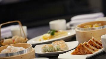 A variety of dishes including dumplings and a slice of cake on a table.