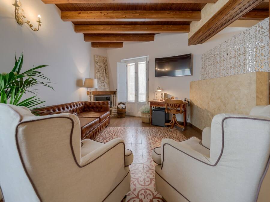 Un accogliente soggiorno con camino, un divano, un tavolino da caffè e una TV montata a parete.