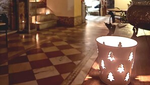 A checkered floor, a fireplace, and a lamp with tree cutouts. - Hotel Argantonio (Cádiz)