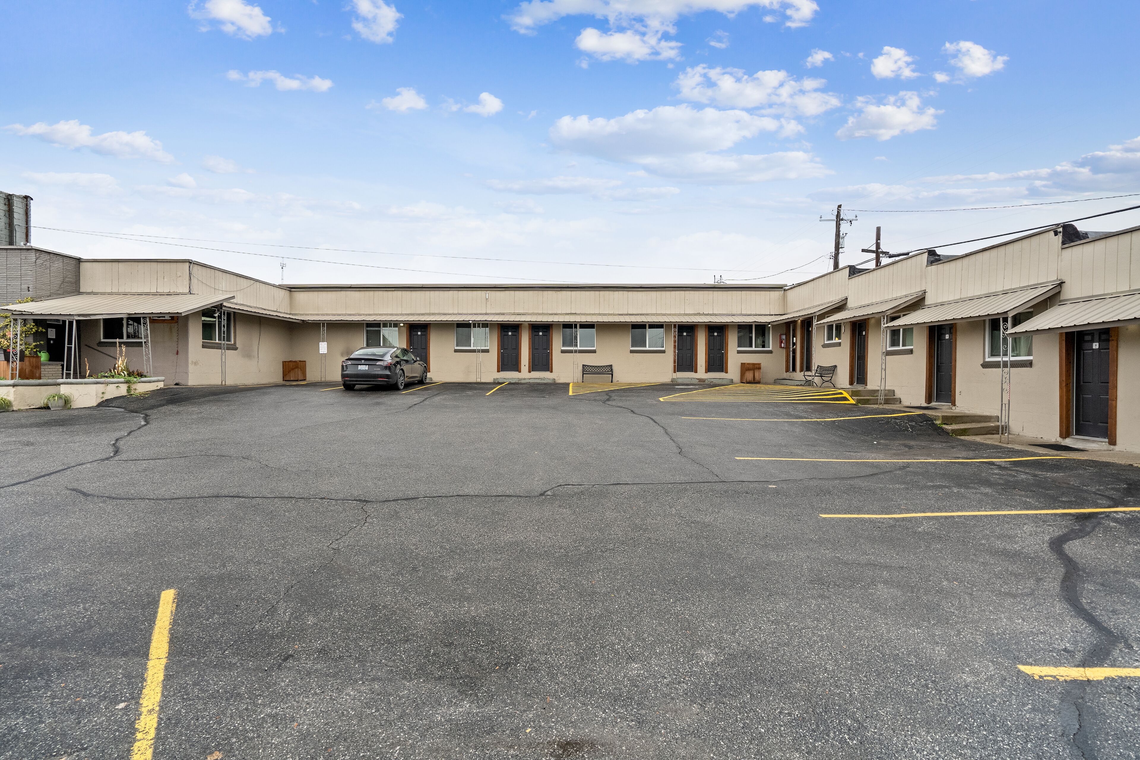 A motel with a central parking area and multiple rooms with individual entrances.