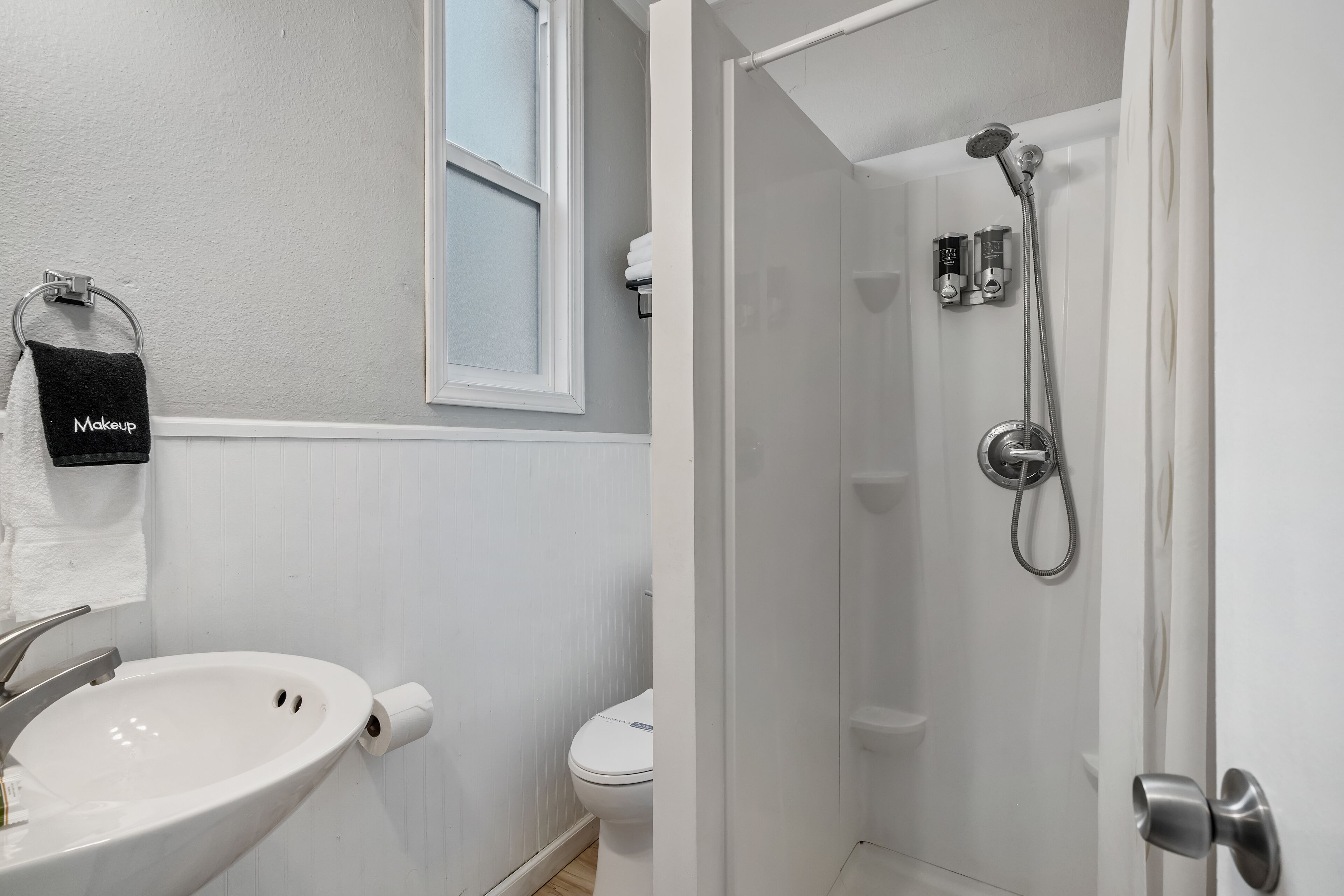 A bathroom with a sink, toilet, and shower.