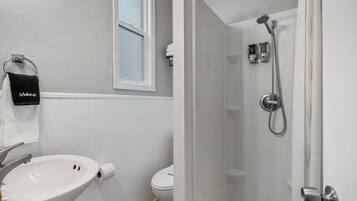 A bathroom with a sink, toilet, and shower.