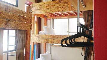 A bunk bed with a wooden headboard and a window above it.