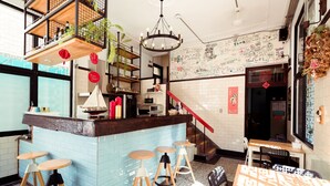Een modern interieur met een bar, zitgedeelte en een trap.