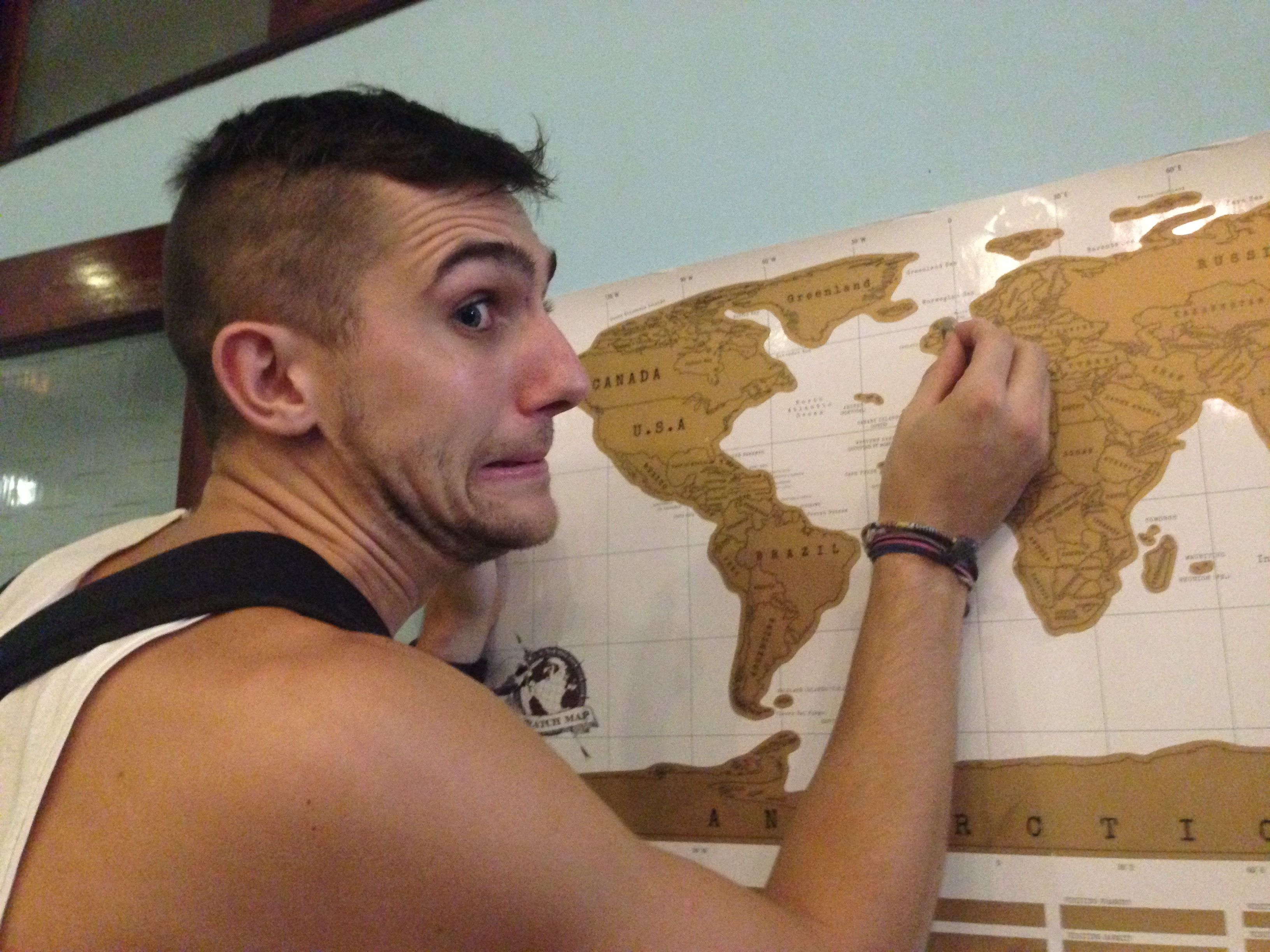 A person pointing at a world map.