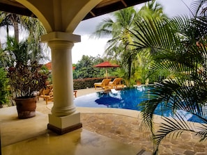 A pool area with lounge chairs and a palm tree. - Los Altos de Eros Boutique Hotel & Spa (Tamarindo)