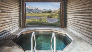 A log cabin with a hot tub and a view of mountains. - Mountain Village Lodge (Stanley)