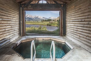 A log cabin with a hot tub and a view of mountains. - Mountain Village Lodge (Stanley)