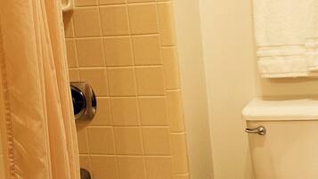 A bathroom with a bathtub, toilet, and a towel rack.