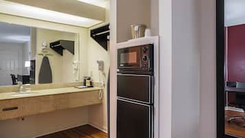 A compact kitchen with a microwave, refrigerator, and a sink with a countertop.