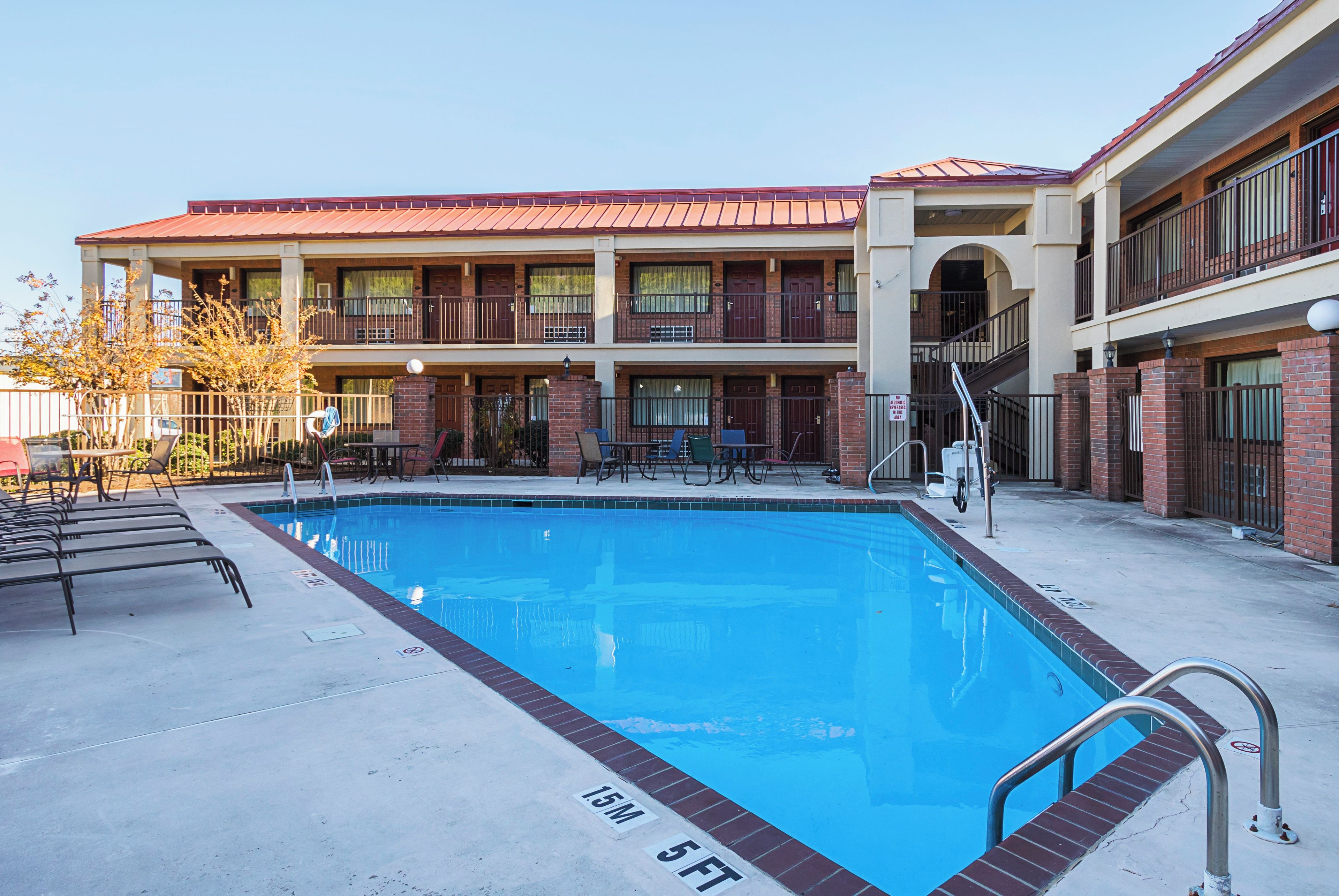 A swimming pool with a 15-meter depth, surrounded by a building with multiple balconies and a brick facade.