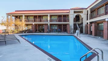 A swimming pool with a 15-meter depth, surrounded by a building with multiple balconies and a brick facade.