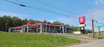 A Red Roof Inn with a red roof, multiple balconies, and a parking lot.