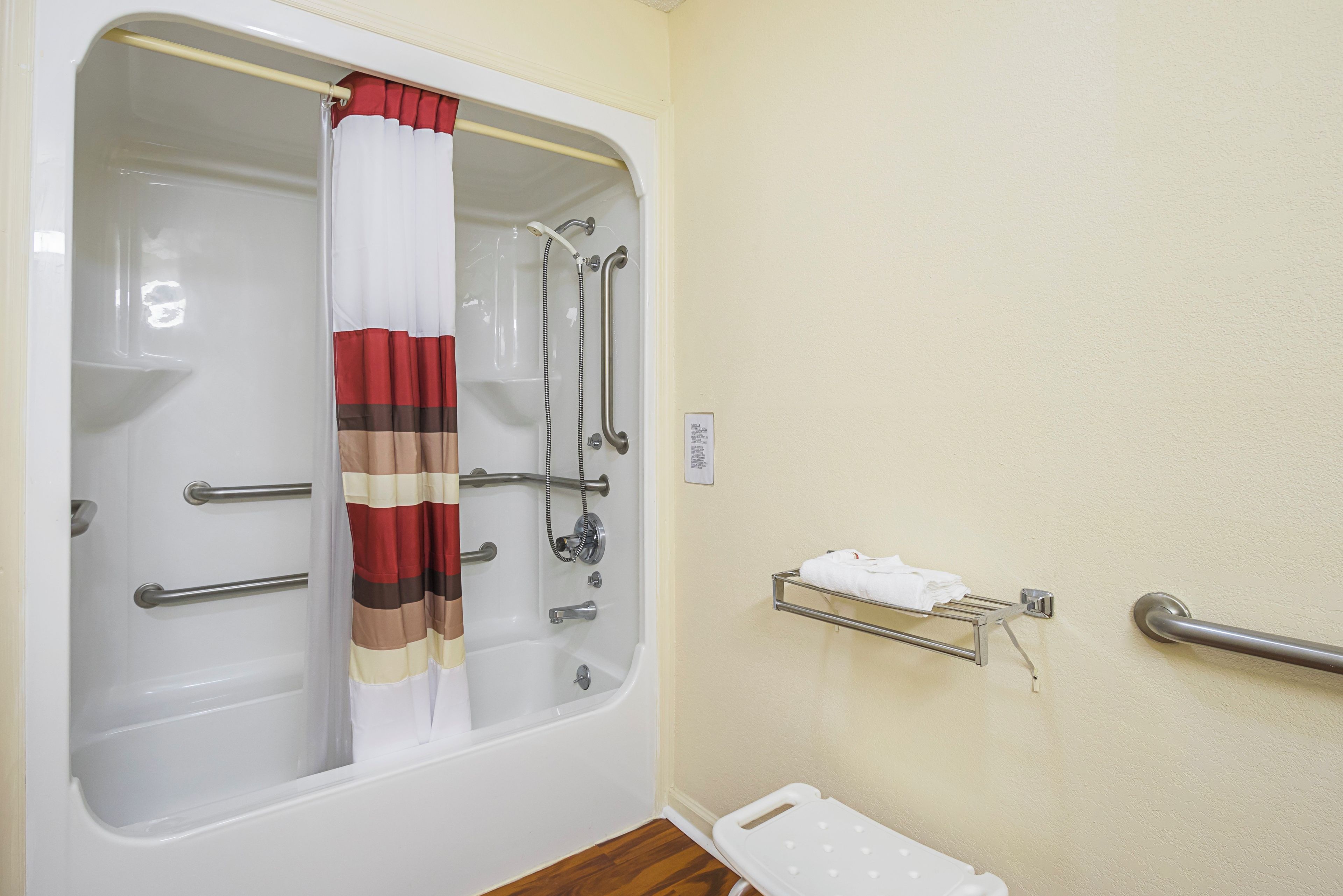 A bathroom with a bathtub, shower, and a towel rack.
