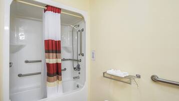 A bathroom with a bathtub, shower, and a towel rack.