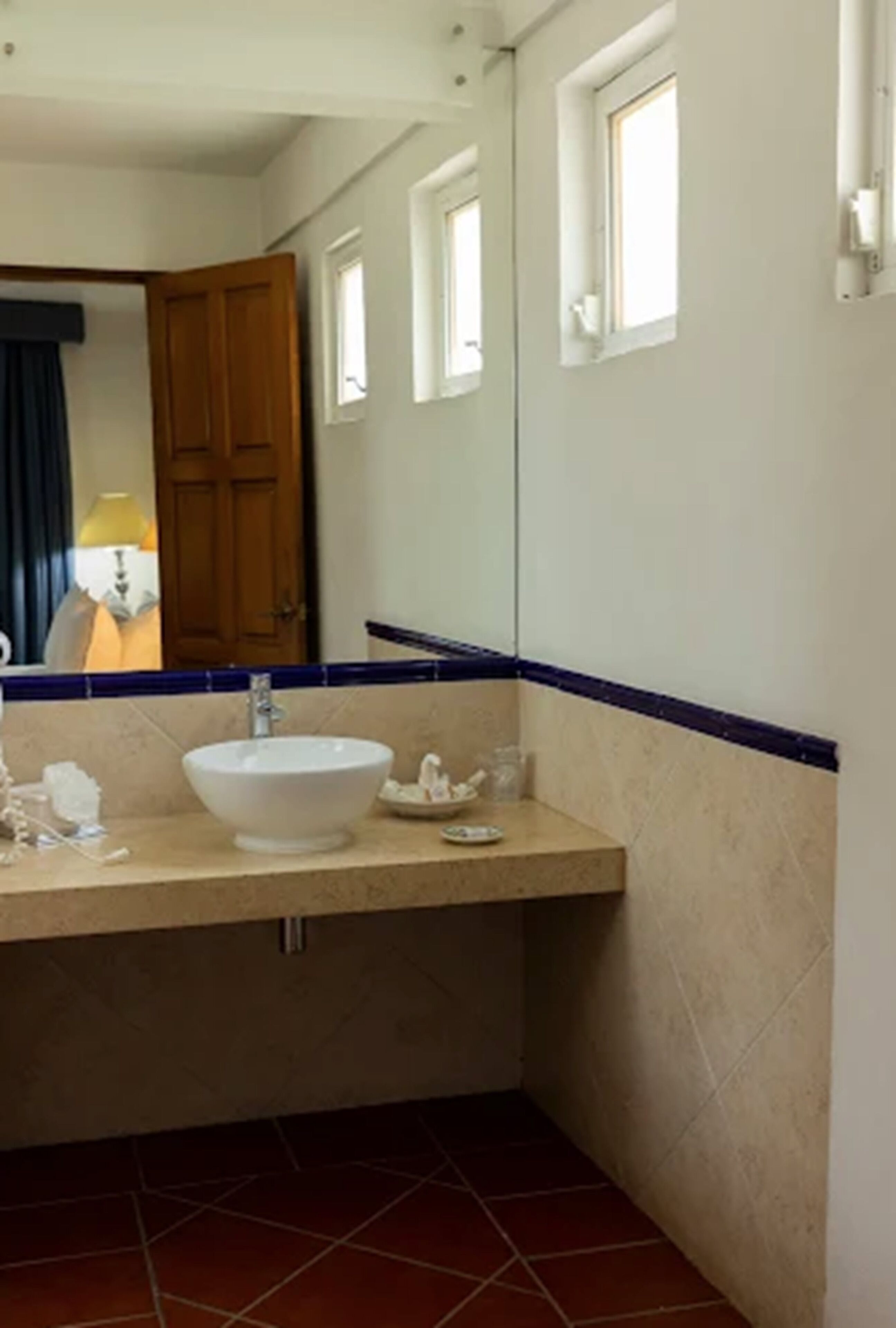Un baño con un lavabo blanco, un espejo y una puerta.