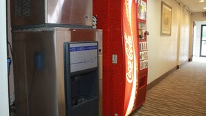 Un pasillo con una máquina expendedora, un refrigerador y un refrigerador de Coca-Cola.