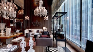 Un interior lujoso con candelabros, un tablero de ajedrez y una vitrina de cristal moderna.