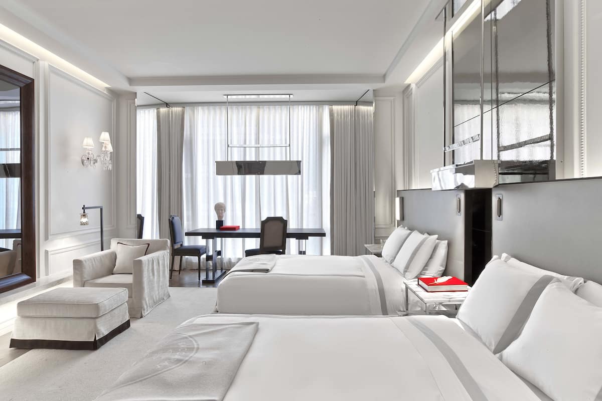Una habitación de hotel moderna con una cama grande, un escritorio y una zona de comedor.
