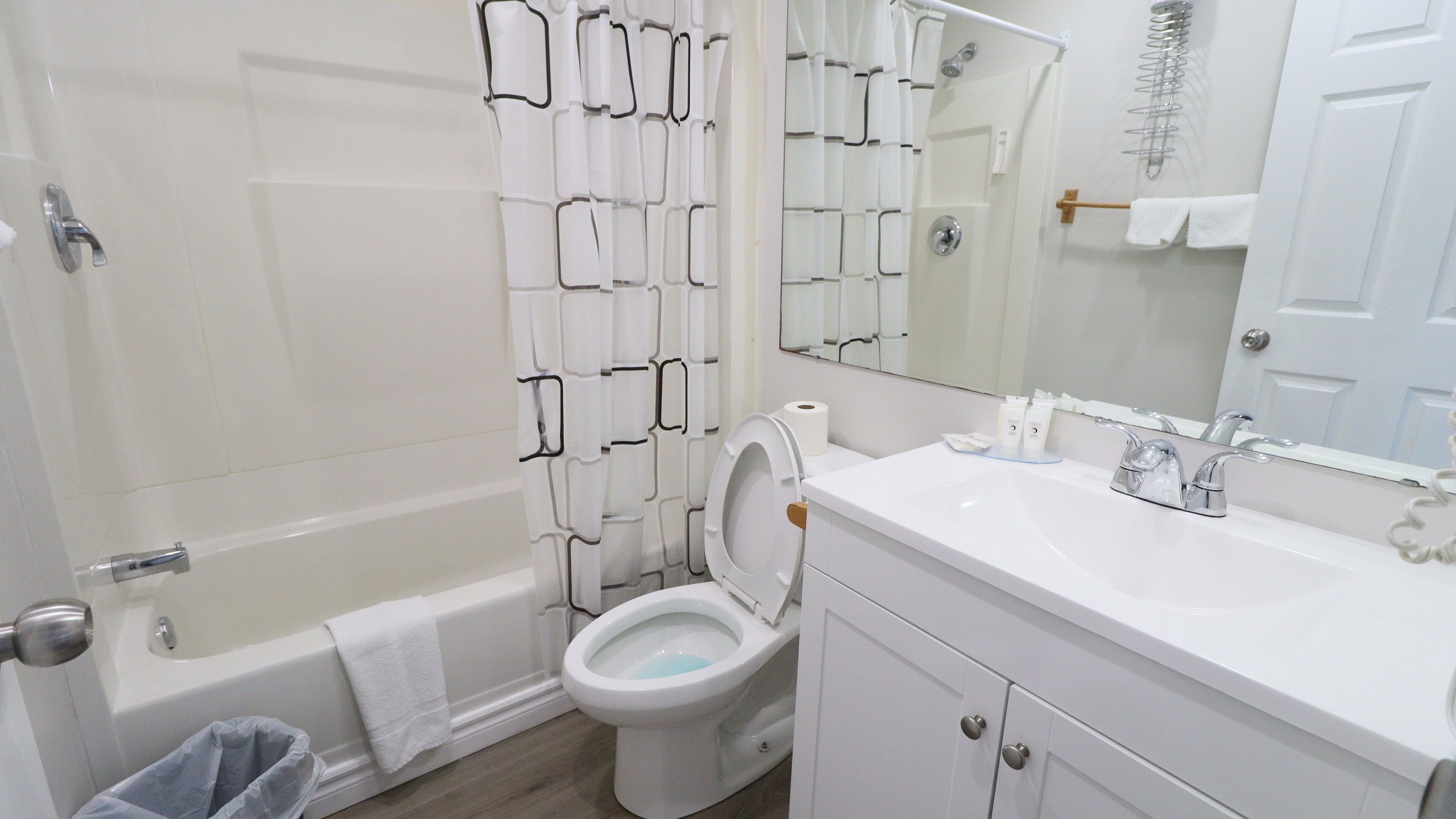 A bathroom with a bathtub, toilet, and sink.