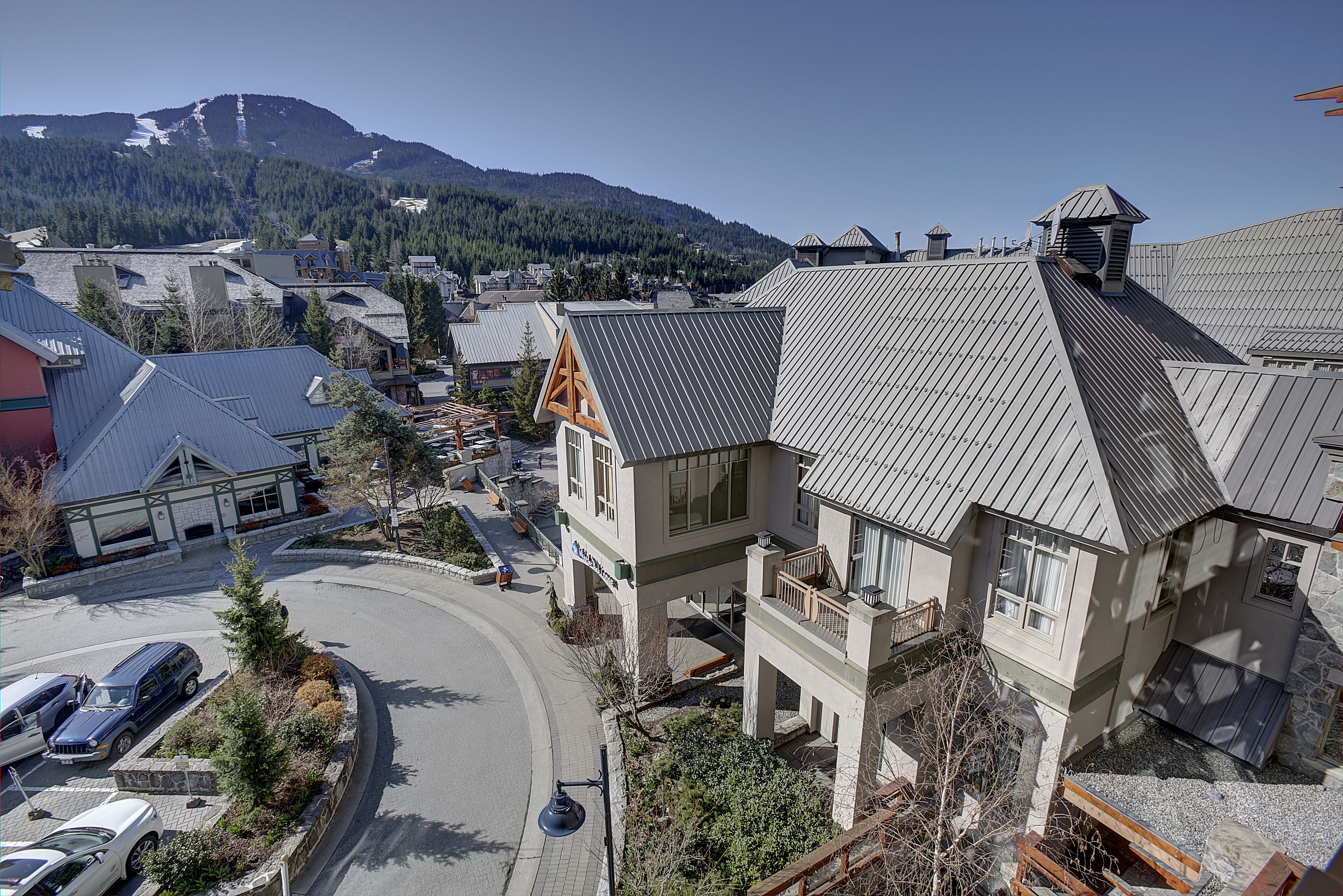 En moderne bygning med skråt tag, stenfassade og balkon.