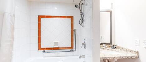 A modern bathroom with a bathtub, shower, and sink.