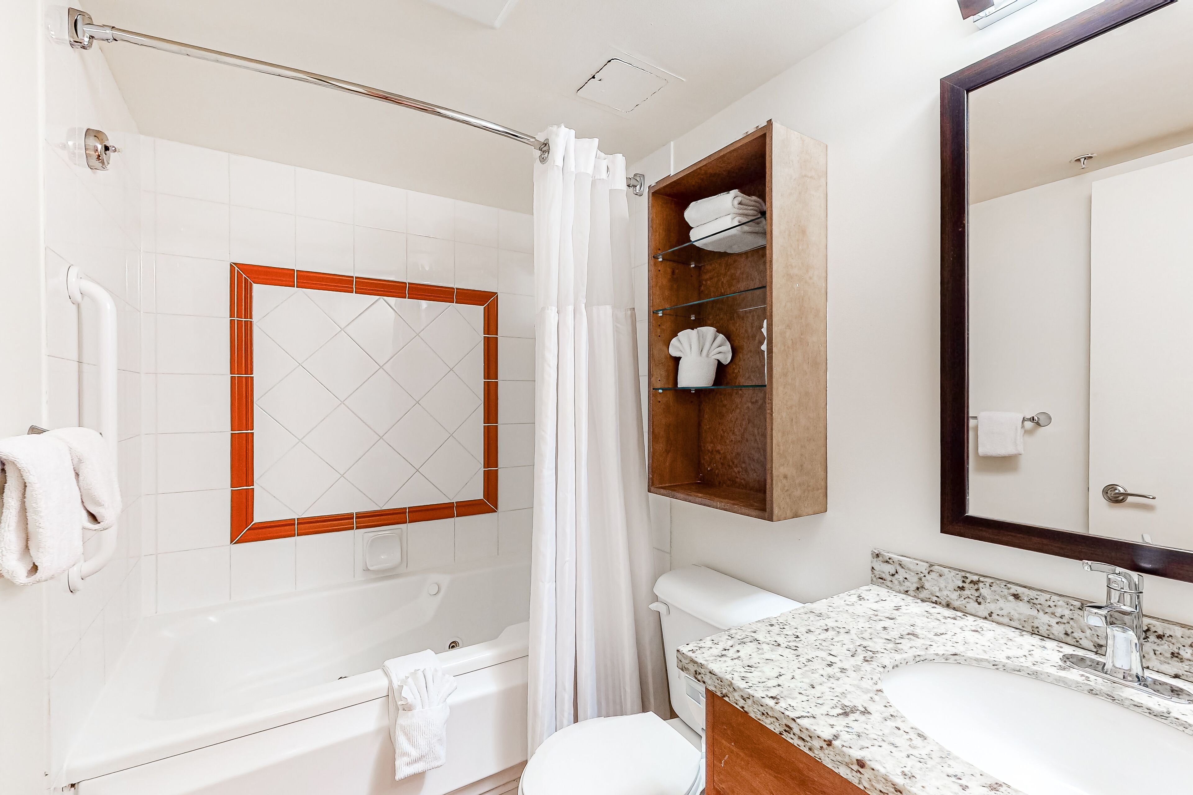 A bathroom with a bathtub, toilet, and sink.